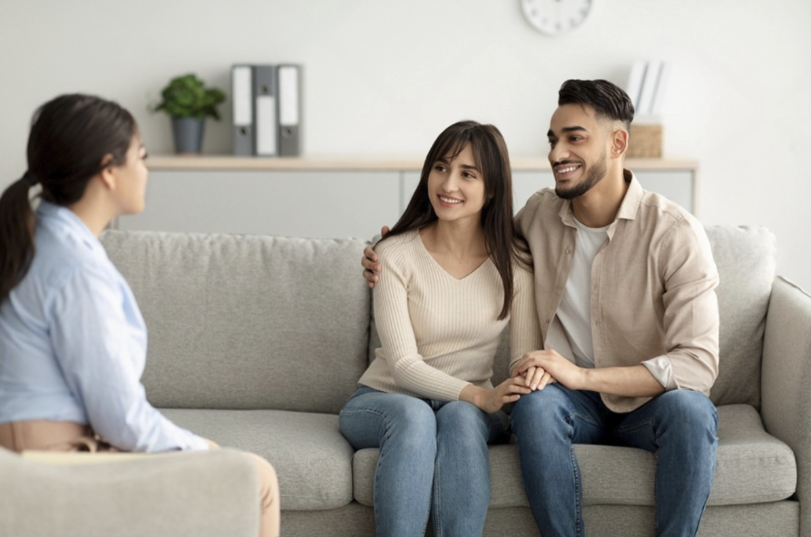 Couple sitting on a couch with a therapist during couples counseling
