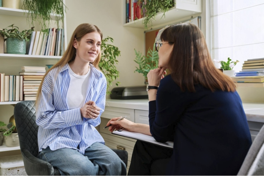 Teenager talking with a therapist who is taking notes