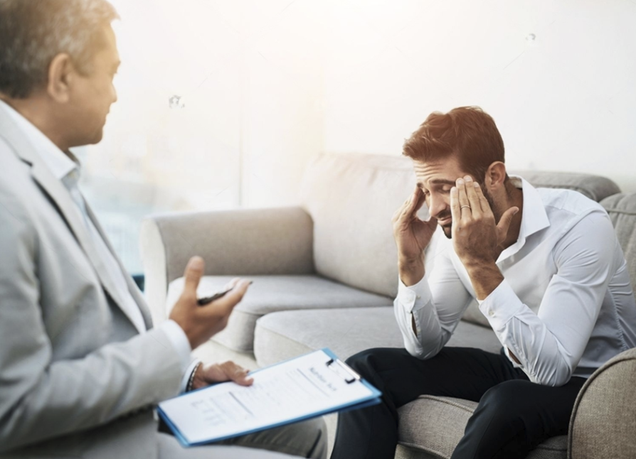 Therapist speaking with a distressed client seated on a couch