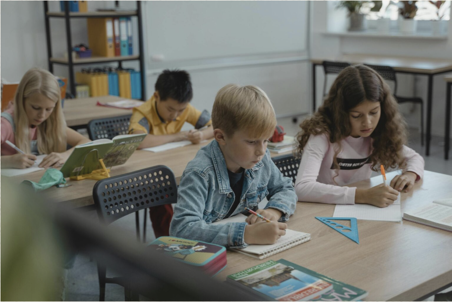 Children working together at a classroom table with a teacher
