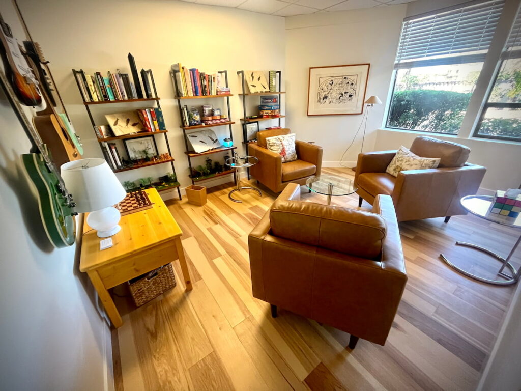 Therapy room with leather chairs and bookshelves at Unfold Psychology Corte Madera